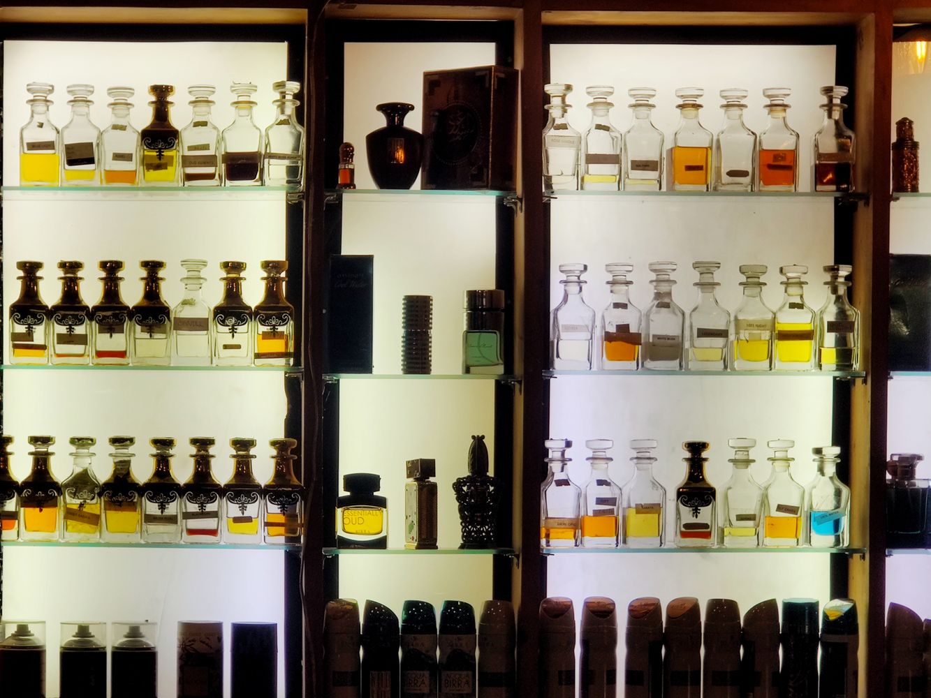 A display of perfume bottles on illuminated shelves